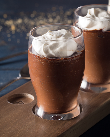 Deux pots de crème au chocolat dans des verres de bière sur un plateau de dégustation