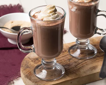 Deux tasses de chocolat chaud garnies de crème fouettée