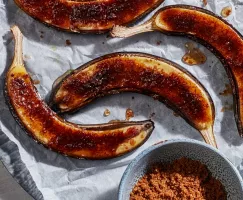 Des bananes rôties, coupées en deux dans le sens de la longueur et garnies de cassonade et de cannelle