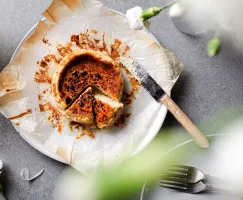 Vue de dessus d'un mini gâteau au fromage basque sur une assiette avec deux morceaux découpés