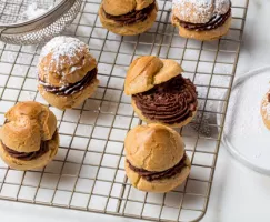 Choux farcis de ganache au chocolat refroidissant sur une grille