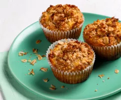 Trois muffins avec garniture streusel à la noix de coco sur une assiette verte