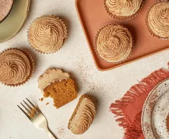 Cupcakes à la citrouille avec glaçage, l’un coupé en deux, sur une table