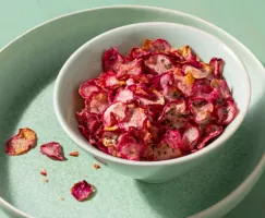 Bol blanc de croustilles de radis au romarin sur un plat de service vert