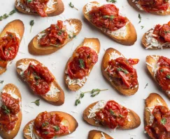 Crostini avec confiture de tomate joliment disposés avec des fines herbes